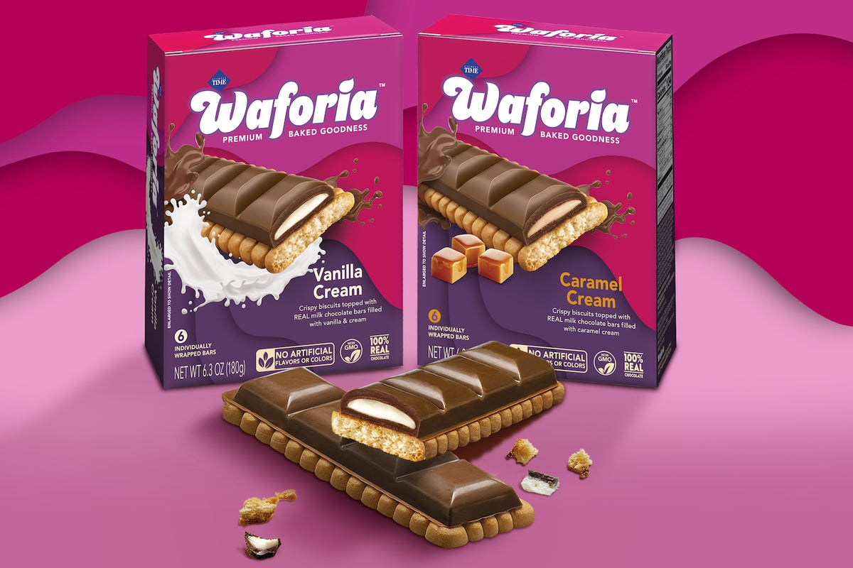 Two Waforia Premium Baked Goodies boxes, one Vanilla Cream and one Caramel Cream, displayed alongside a broken chocolate-covered wafer bar on a pink and magenta background.